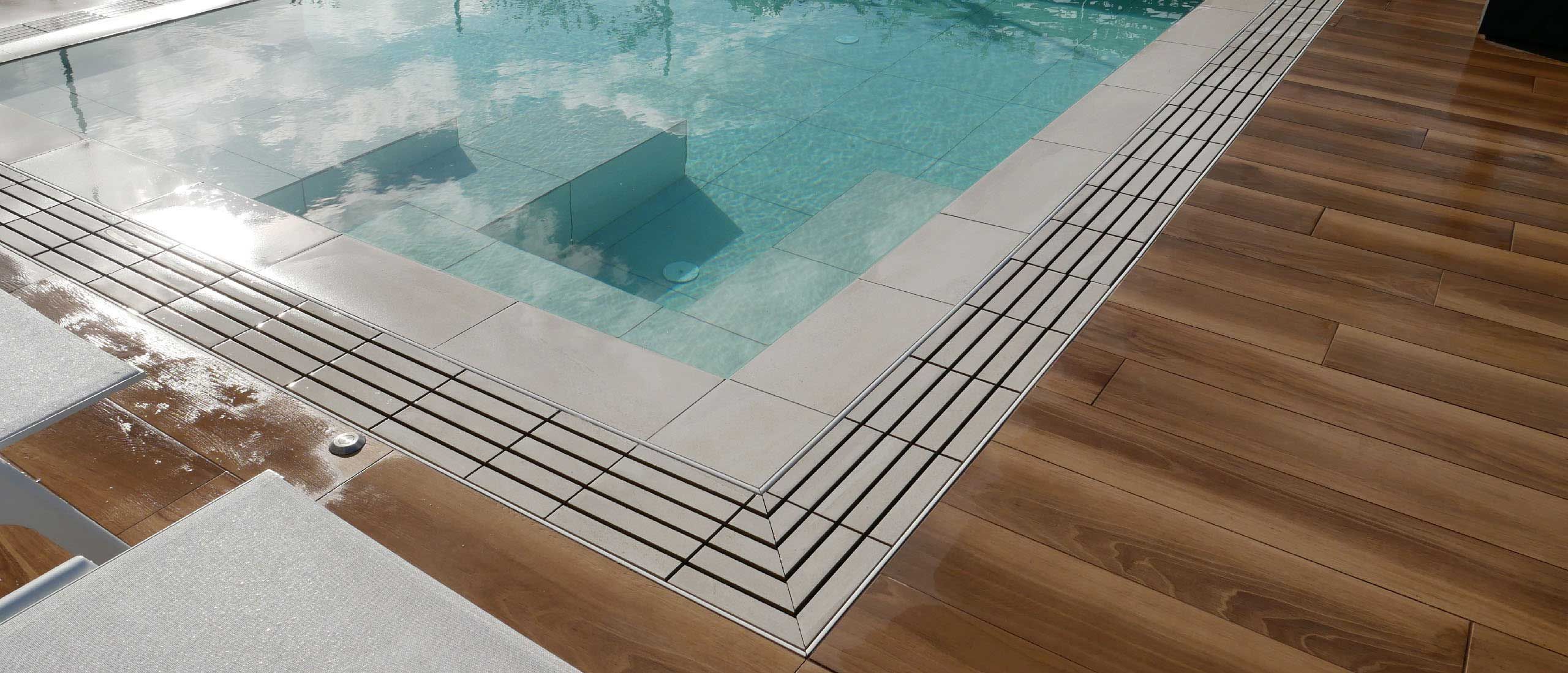 piscina a sfioro con pavimento in gres effetto legno naturale Wood
