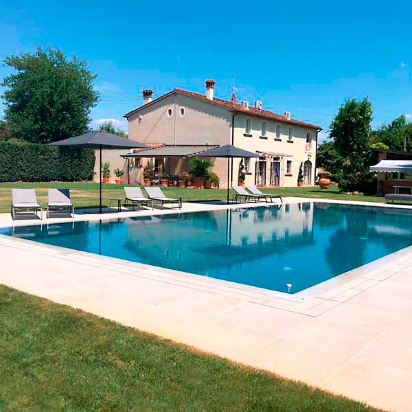 Piscina a sfioro con pavimento e griglia directa effetto cemento minimal beige