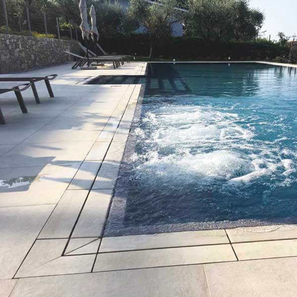 piscina a sfioro con gliglia effetto cemento minimal beige