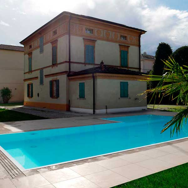 Piscina a sfioro con pavimento e griglia directa effetto pietra meta beige