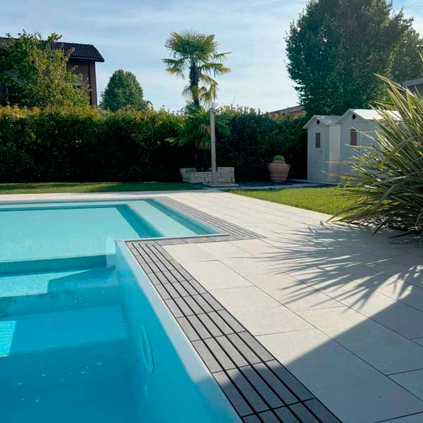 piscina a sfioro con griglia directa meta grey e pavimento esterno piscina meta white