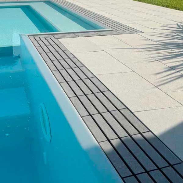 piscina a sfioro con griglia directa meta grey e pavimento esterno piscina meta white