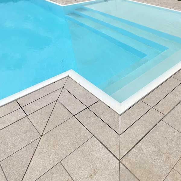 piscina a sfioro con pavimento in gres effetto pietra naturale felix