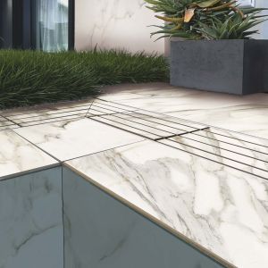 Immagine di bordo piscina con pavimento in gres per piscine a sfioro effetto marmo Calacatta - dettaglio angolo